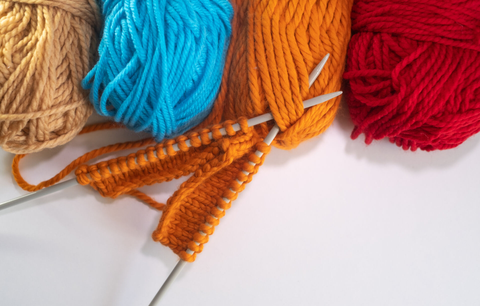 Balls of colored wool yarn on white background. Knitting project on progress. Copy space